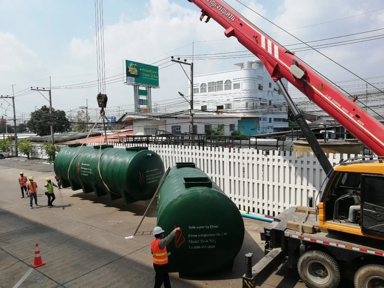 ทีมงานควบคุมการยกถังบำบัดน้ำเสียด้วยรถเครนหน้างาน